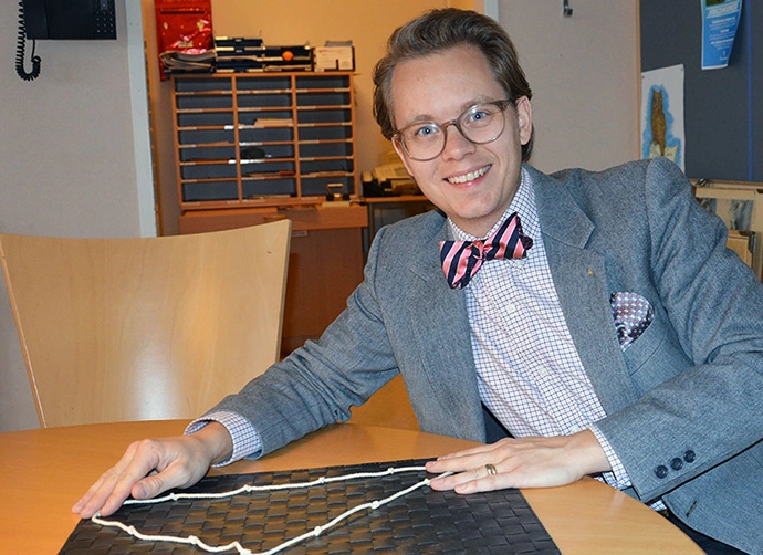 person i kostym och fluga sitter vid ett bord