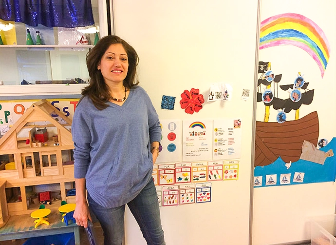 lärare står vid vägg med pedagogiskt material