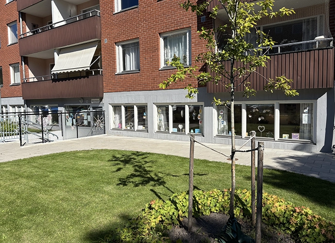 Exteriör med gräsmatta framför tegelbyggnad