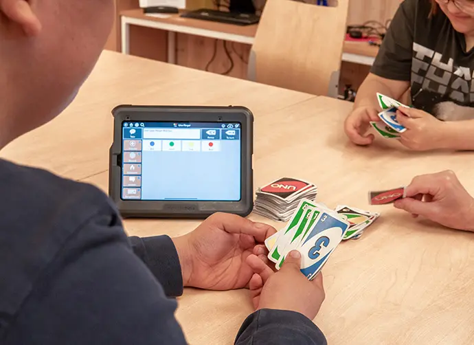 Elever spelar kortspel tillsammans med stöd av surfplatta.