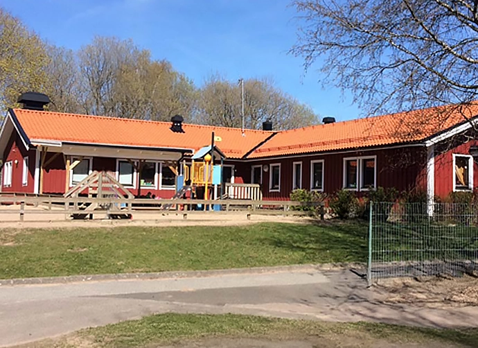 Förskolegården med den röda förskolan i bakgrunden