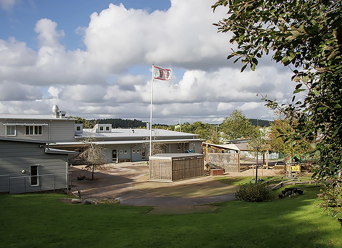 Förskolegården med flaggstång och förskolan i bakgrunden