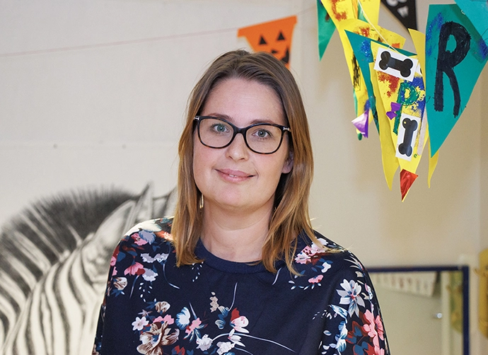 lärare på förskolan  står i närbild och tittar in i kameran