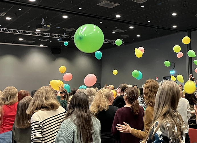 en grupp pedagoger med en ballonger i luften ovanför dem