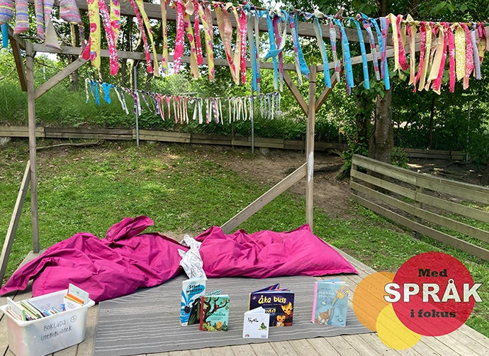böcker står uppställda på en filt på förskolegårdens gräsmatta