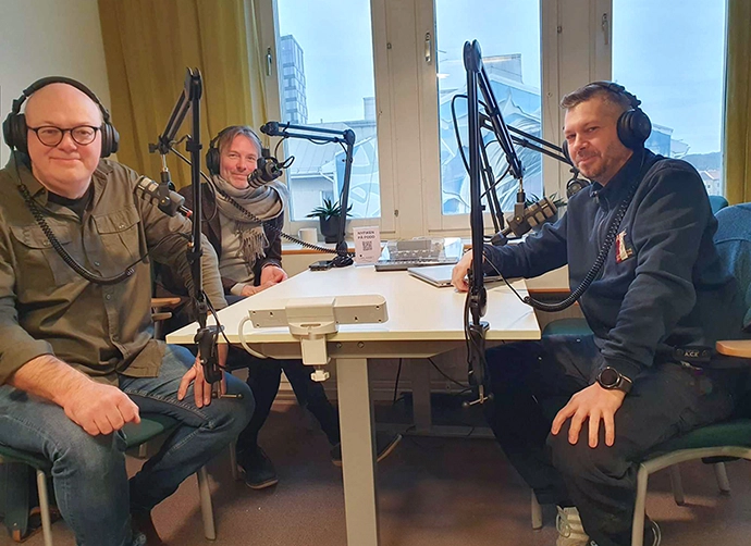 tre personer sitter i en poddstudio