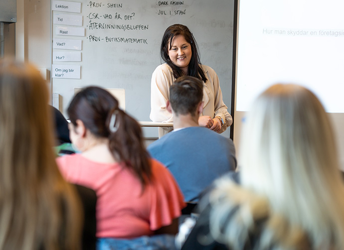 En lärare står i klassrum och undervisar.