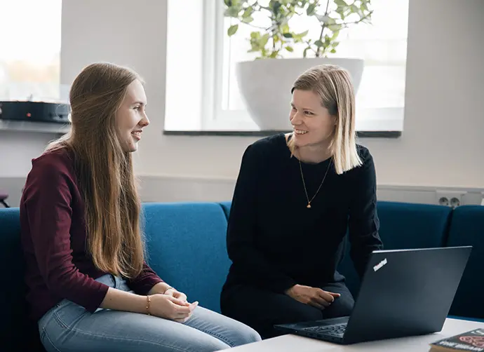 Elev och lärare sitter i en lugn miljö och samtalar med dator som stöd.