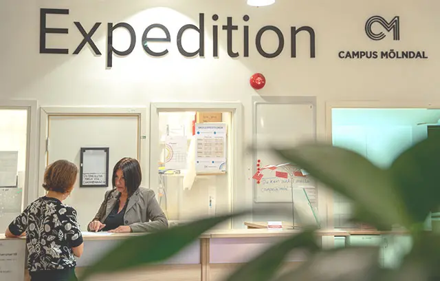 Två personer står och pratar vid skolexpeditionen.