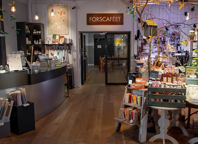 I förgrunden syns ett bord med varor som är till salu i museets butik. Till vänster syns en receptionsdisk. I bakgrunden syns en ingång till ett annat rum. 