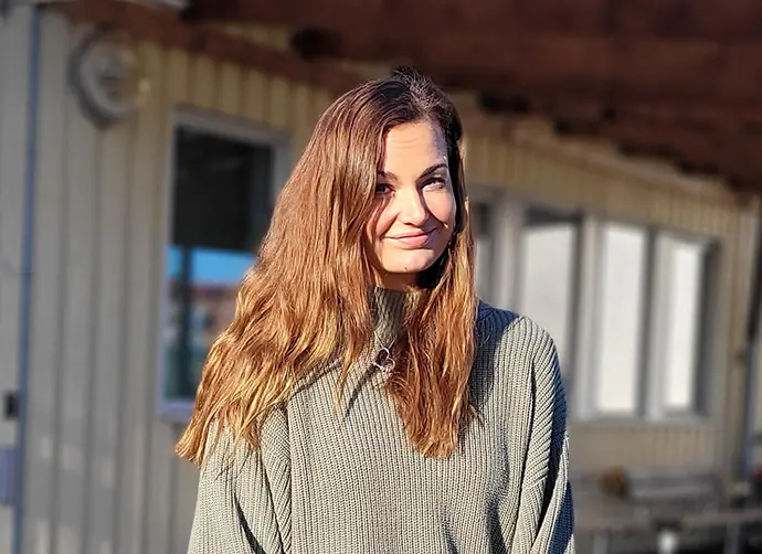 Signe Skoog Stjepic, speciallärare står framför en gul byggnad.