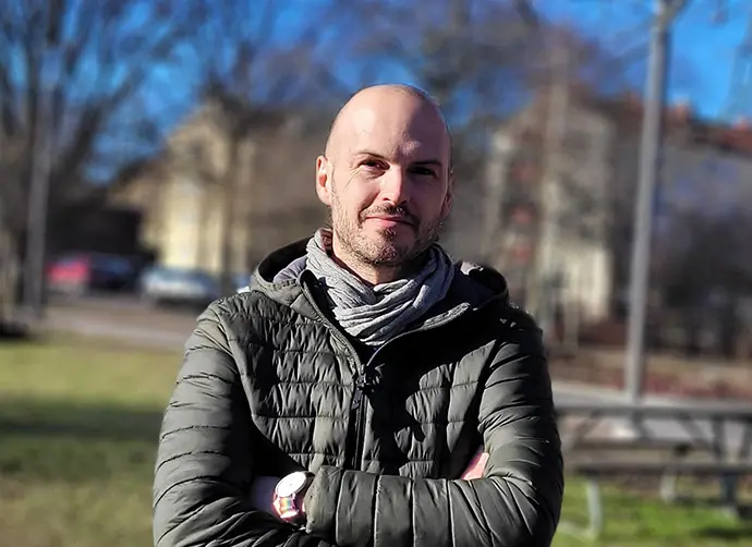 Hannes Helmin, aktiveringspedagog står utomhus i en svart jacka.