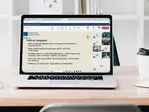 Skärm på en laptop visar ett digitalt möte med bild på en presentation och deltagarna på mötet.