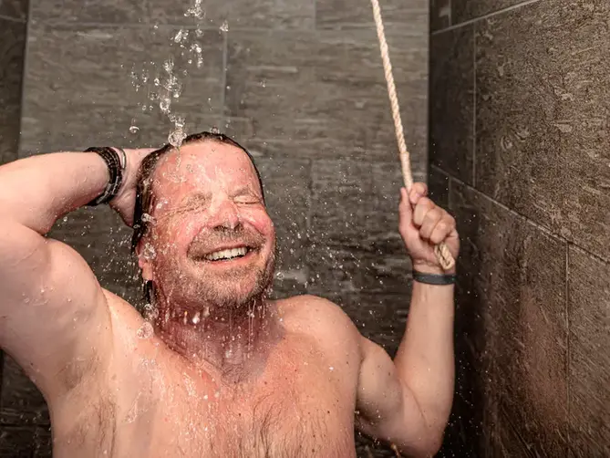 Man som duschar i hinkduschen i Åbybadet.