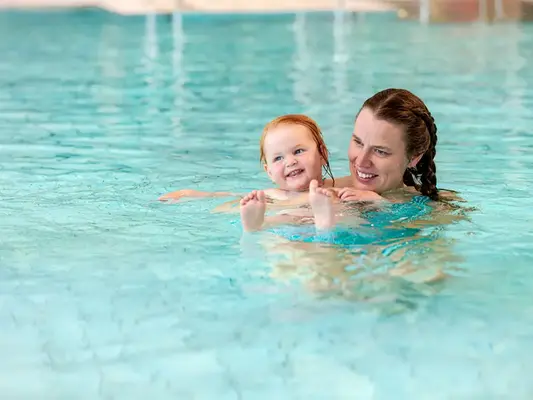 Mamma och dotter i varmvattenbassäng i Åbybadet.
