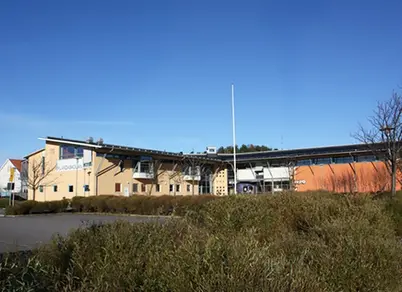 Framsida skola med buskar i förgrunden