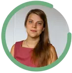 Emelie Åkerblom har långt brunt hår och bär en vinröd ärmlös klänning. Hon tittar in i kameran med trevlig min