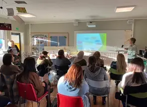 en samling mentorer sitter i grupp och lyssnar på en utbildare