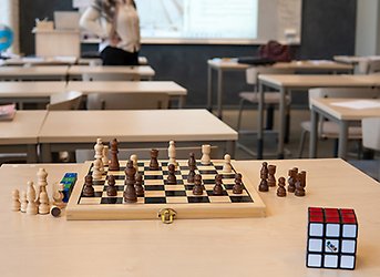 Schackspel uppställt på bord i klassrum.