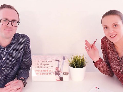 En man och en kvinna sitter runt ett bord och ler mot kameran.
